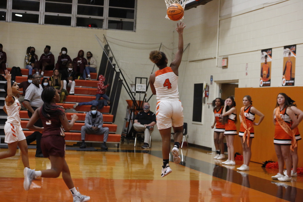 A basketball player is jumping to the air for a ball.