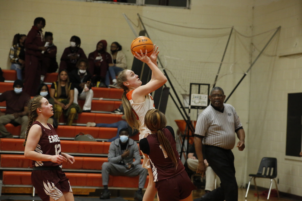 A girl is jumping up to reach the ball