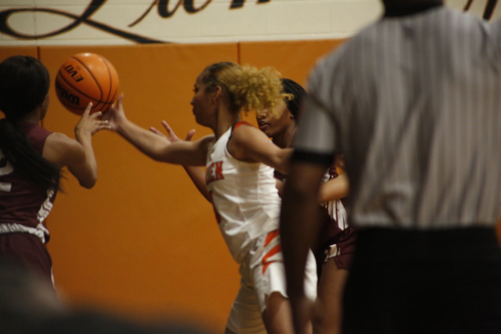 A group of people playing basketball on an indoor court.