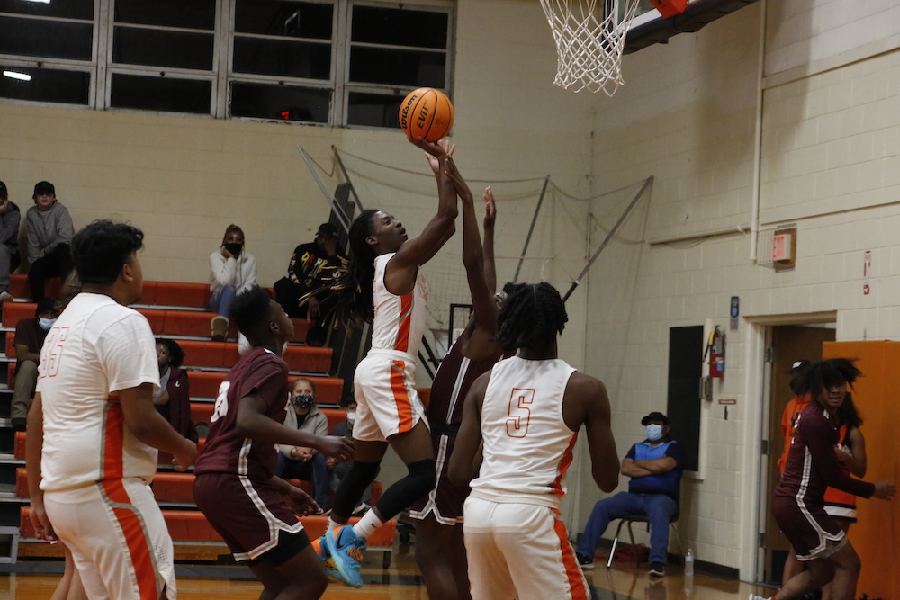 A group of people playing basketball in an arena.