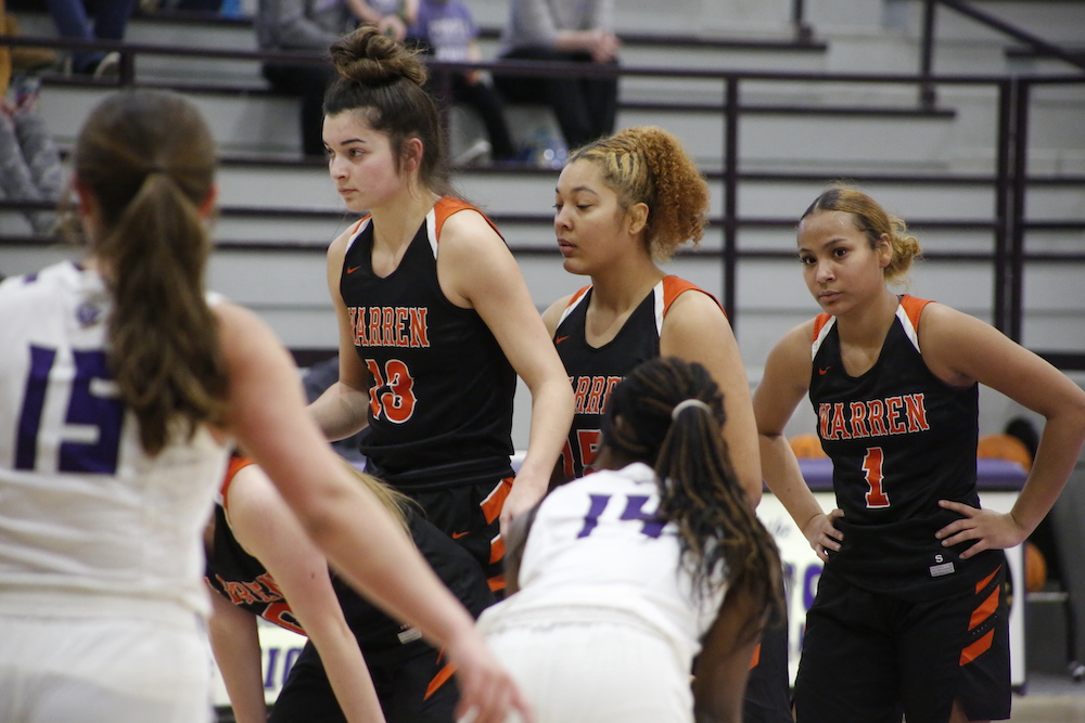 A group of girls are playing basketball on the court.