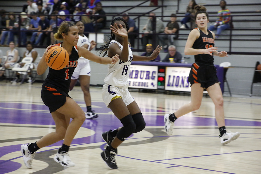 A group of girls playing basketball on the court.
