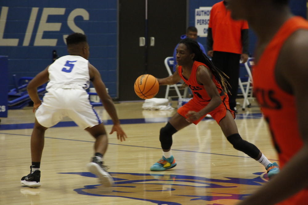 A couple of men playing basketball on a court.