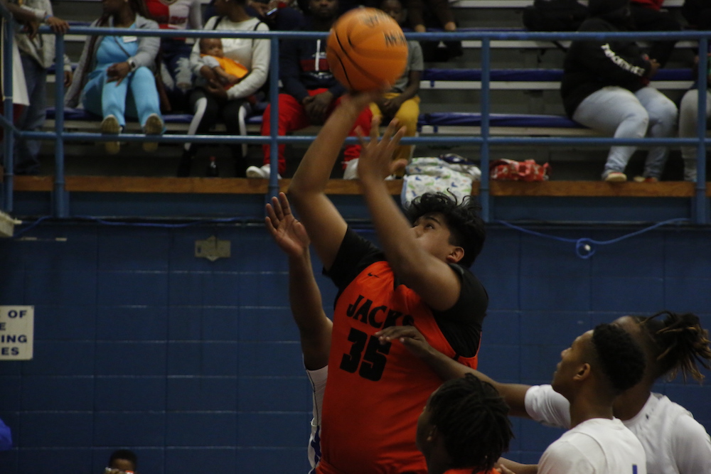 A group of people playing basketball in an arena.