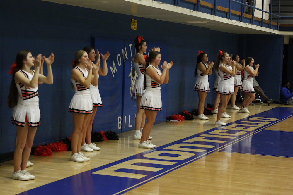 A group of cheerleaders standing in front of the audience.