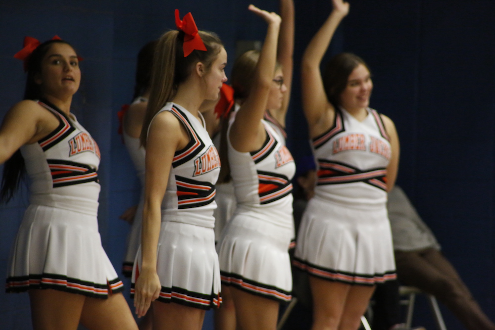 A group of cheerleaders are standing in formation.