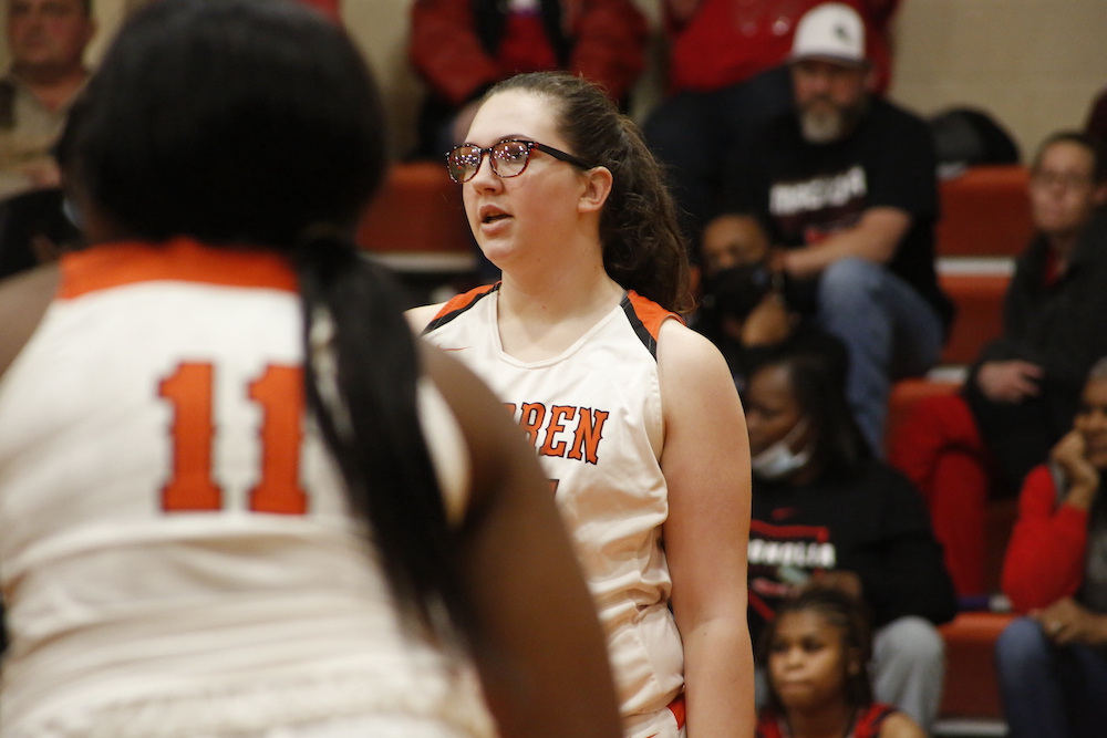 A girl in glasses is standing on the court