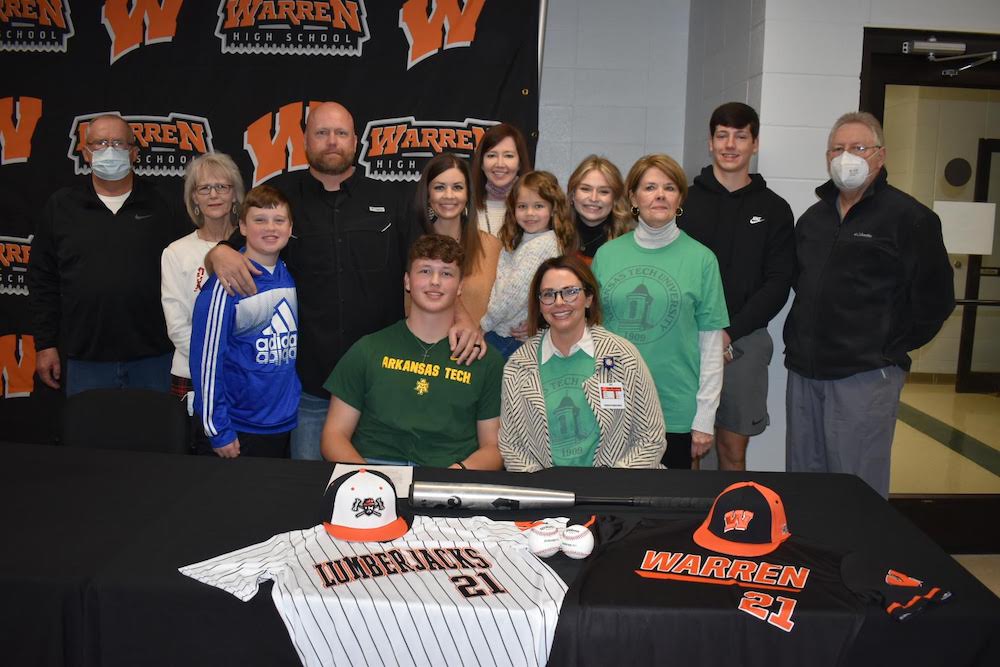 A group of people standing around a baseball player.