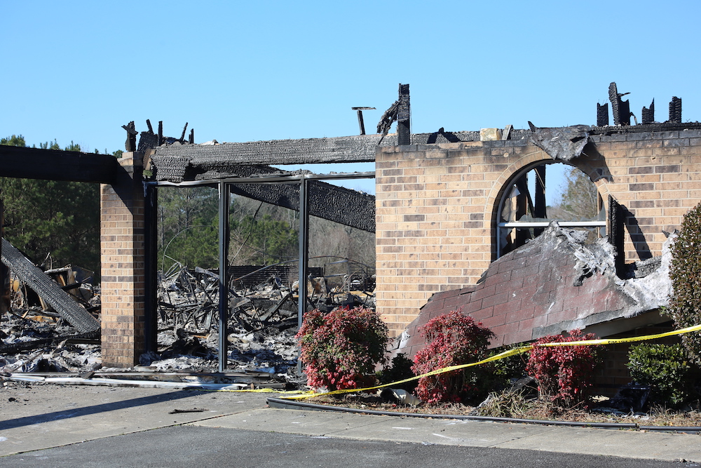 A fire damaged building with the roof missing.