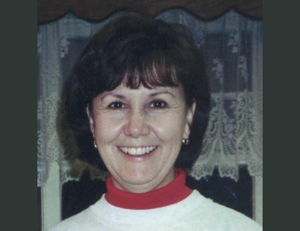 A woman with short hair wearing a white shirt.