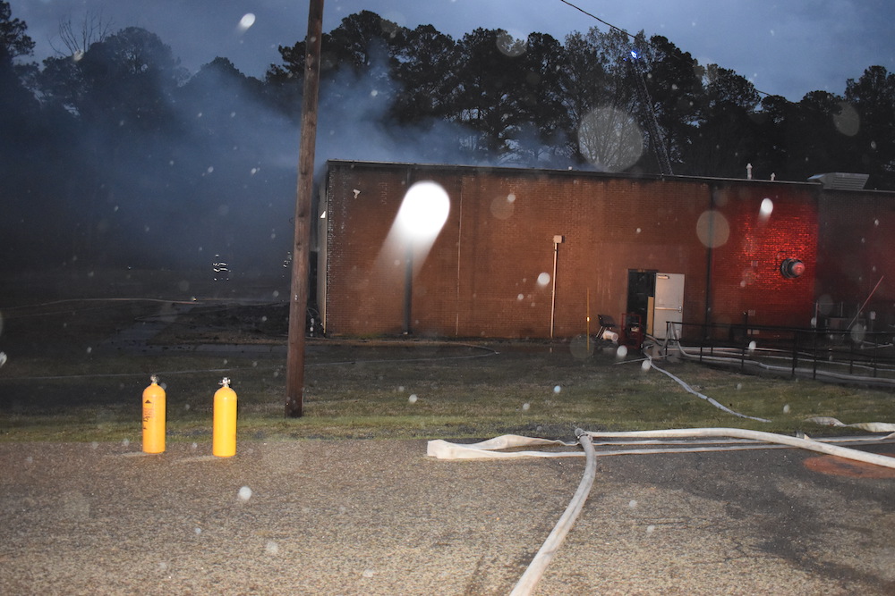A fire hydrant is lit up in the dark.