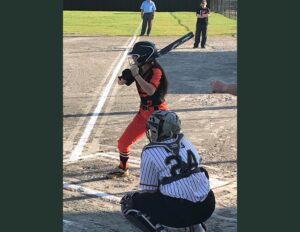 A baseball player is swinging at the ball.