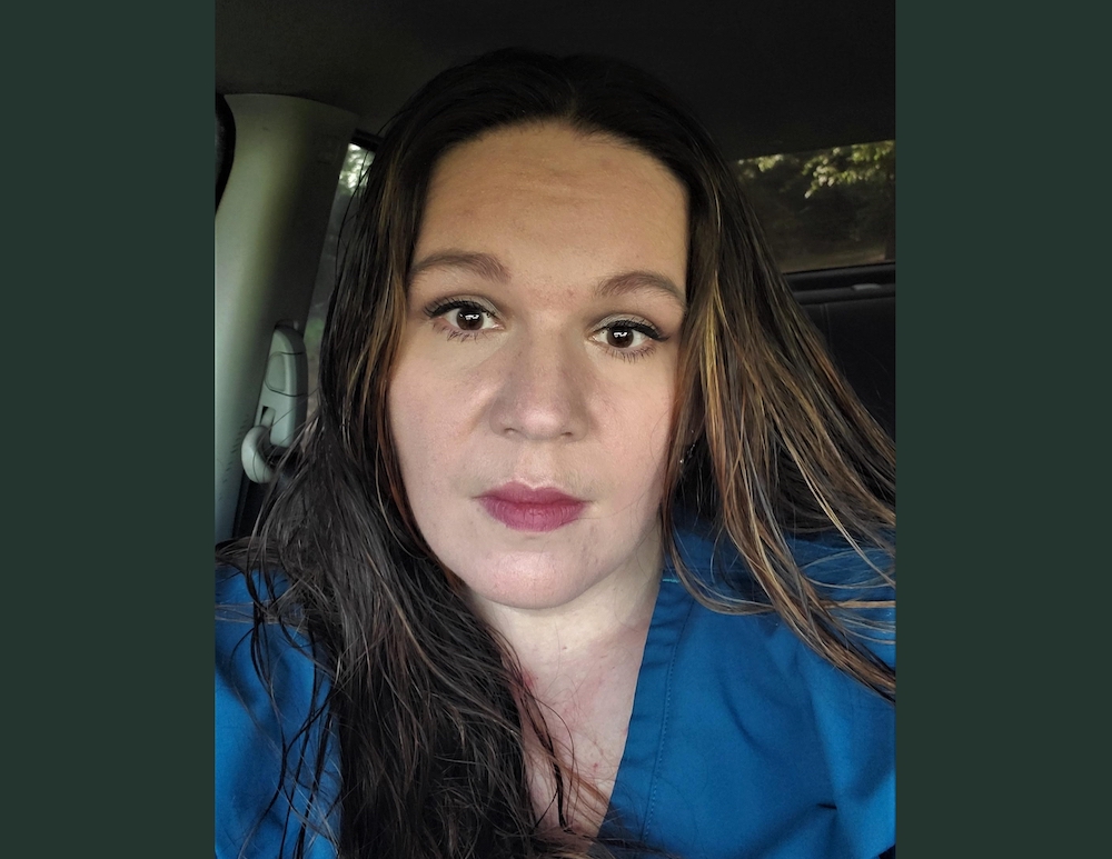 A woman with long hair sitting in the back of a car.