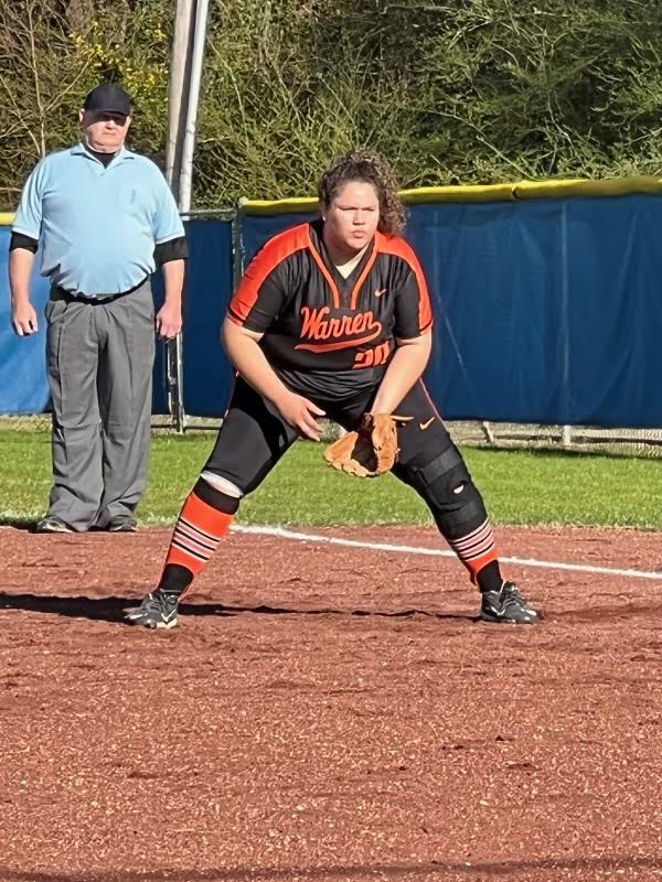 A softball player is about to throw the ball.