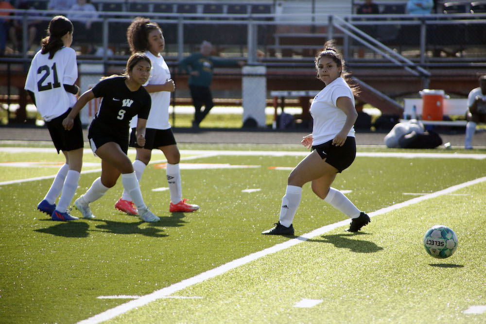 A softball player is about to throw the ball.