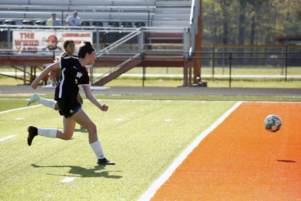 A softball player is about to throw the ball.