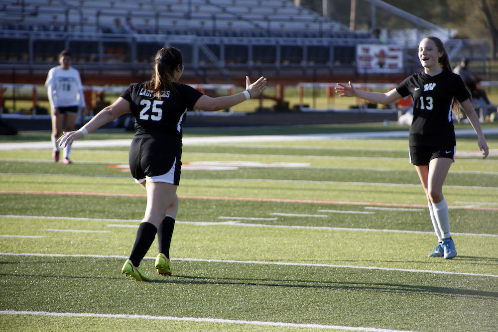 A softball player is about to throw the ball.