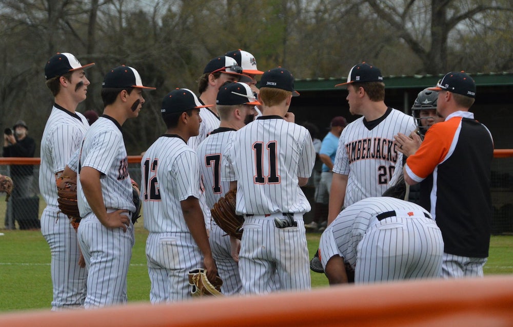 A group of baseball players standing on top of a field.