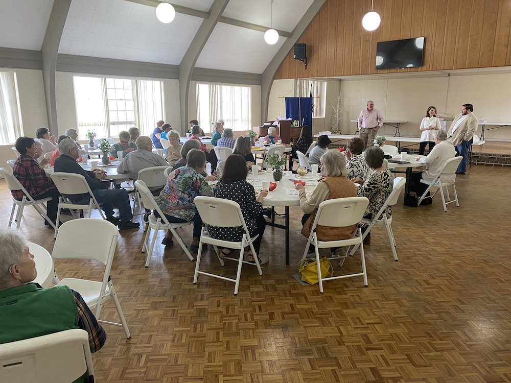 A group of people sitting around tables in a room.