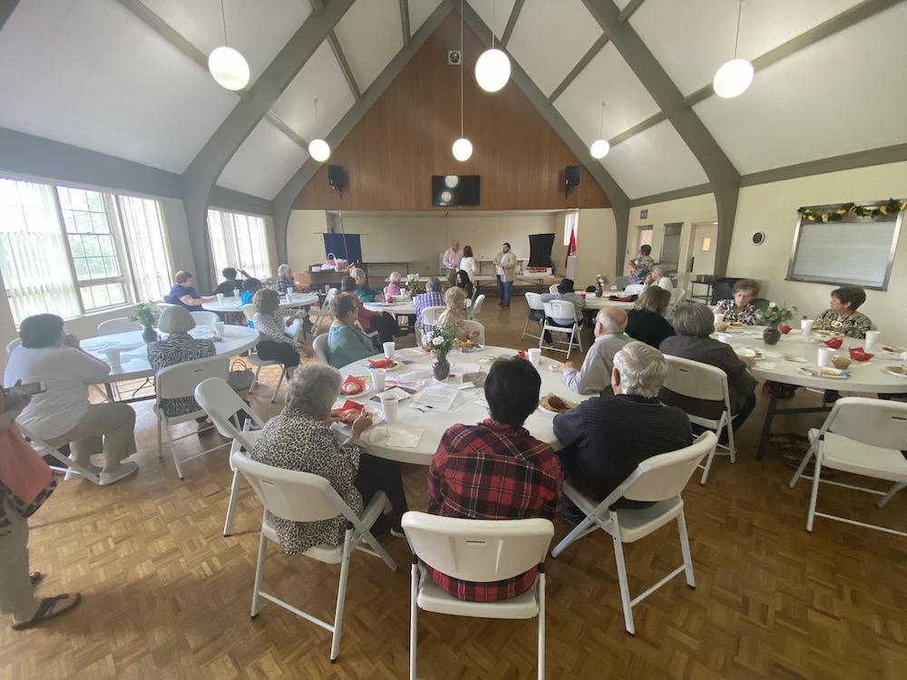 A group of people sitting around tables in a room.