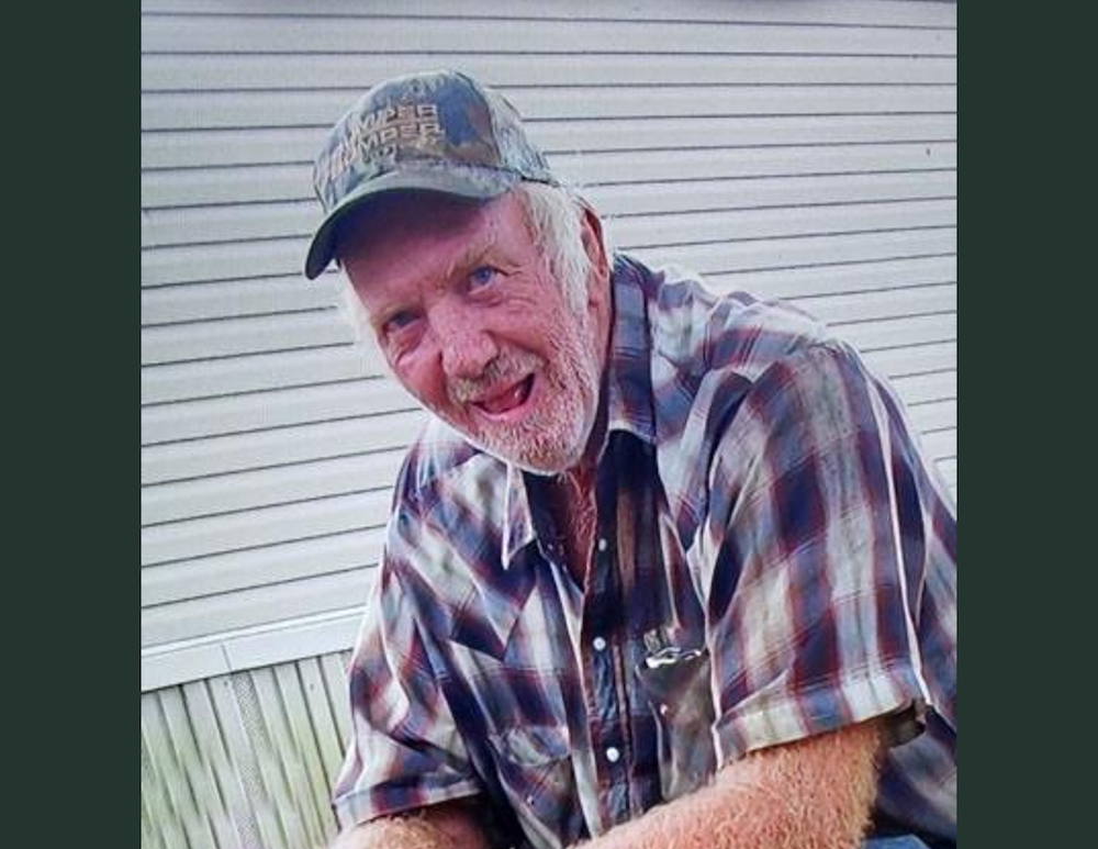 A man wearing a hat and plaid shirt.