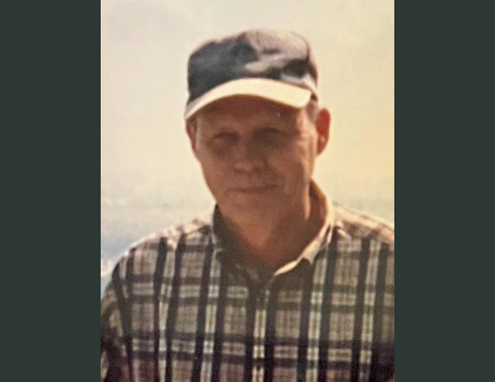 A man wearing a hat and plaid shirt.