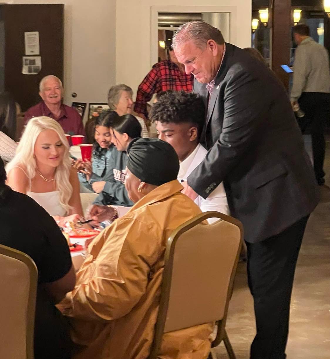 A group of people sitting at tables with food.