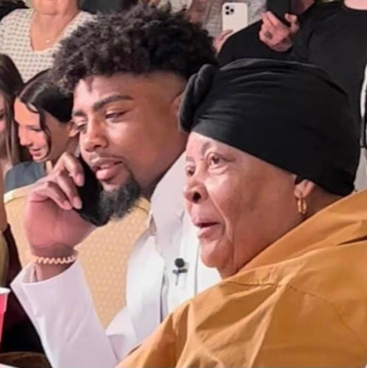 A man and woman sitting next to each other on the phone.