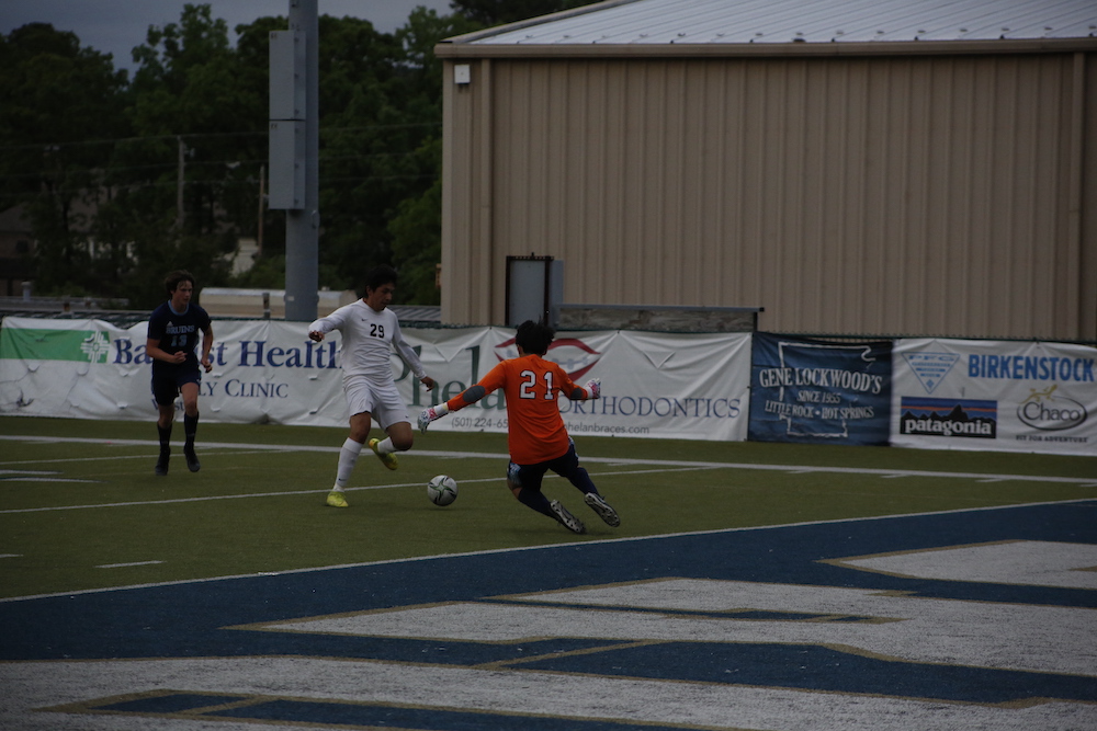 A group of people playing soccer on a field.