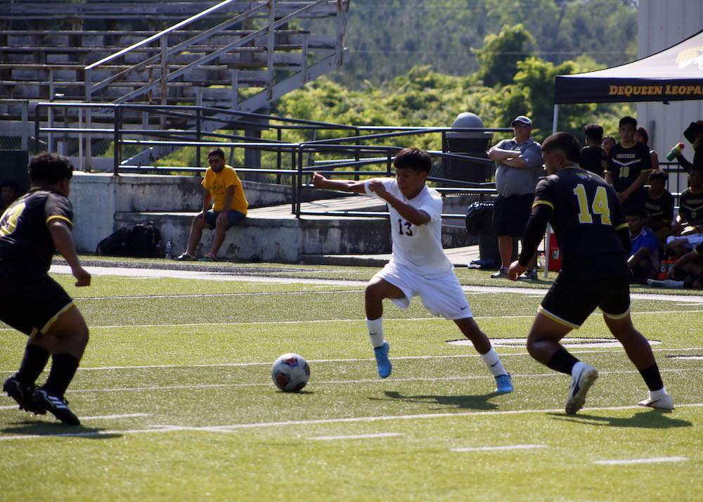 A group of young men playing soccer on a field.