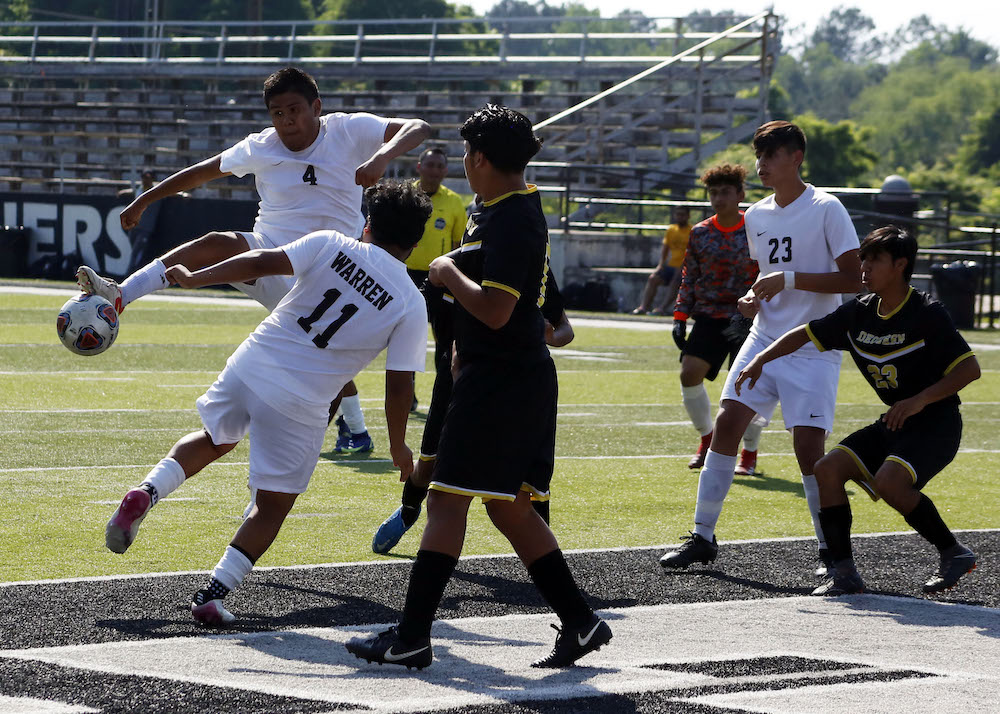 A group of young men playing soccer on a field.