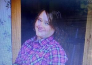 A blurry picture of a girl in plaid shirt.