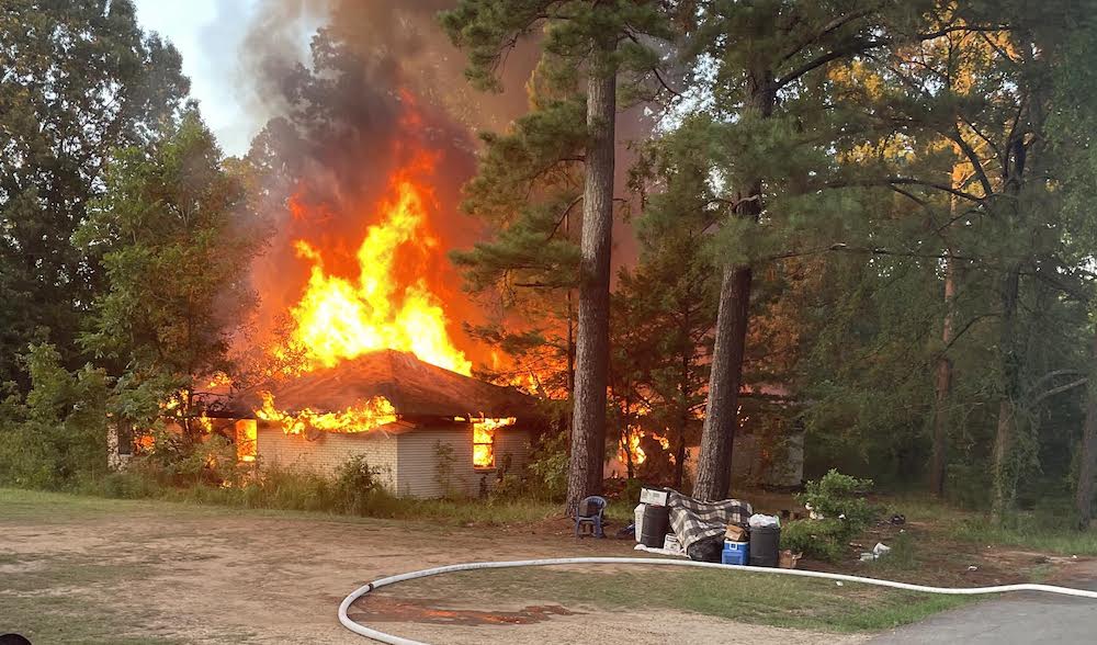 A house on fire with trees around it