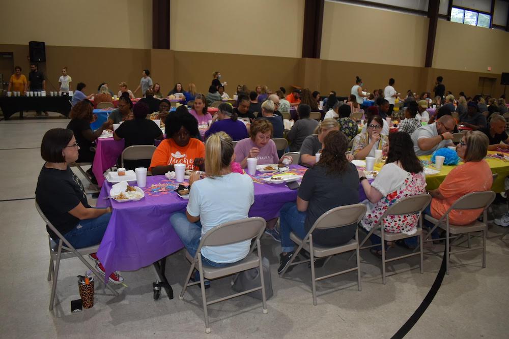 A group of people sitting at tables eating food.