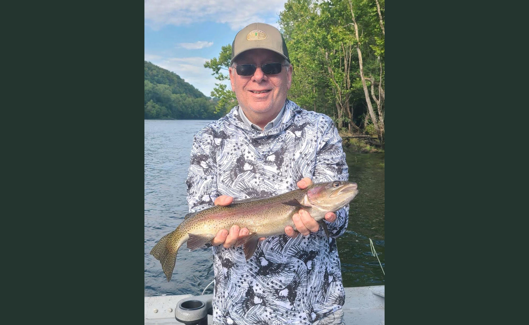 A man holding a fish while standing on top of a boat.