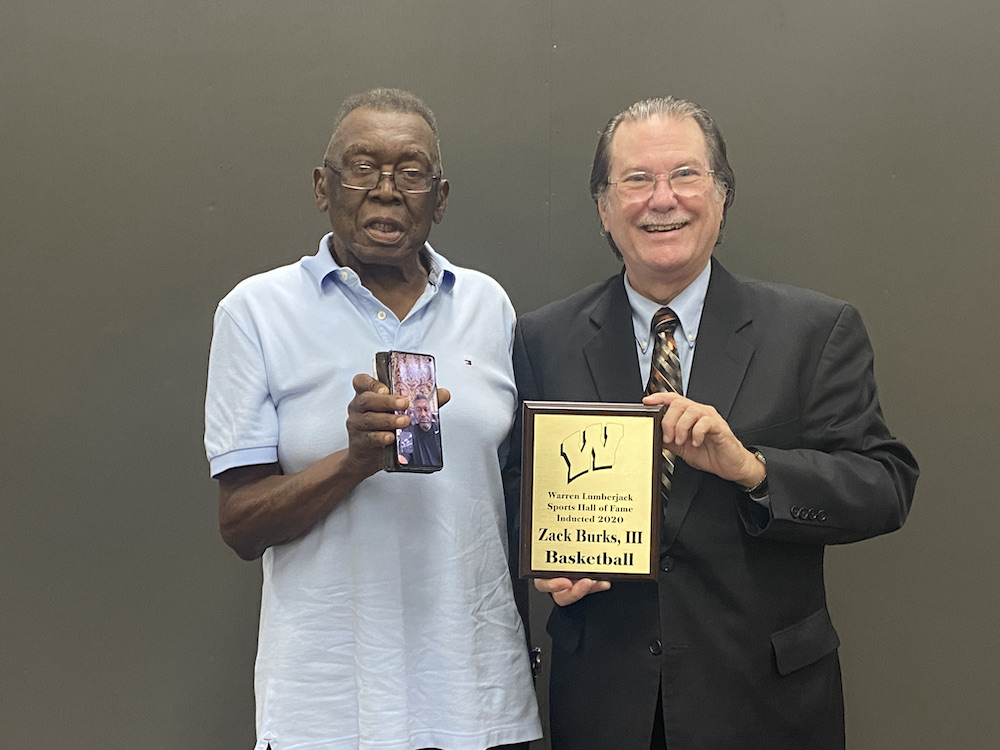 Two men holding a plaque and a cup