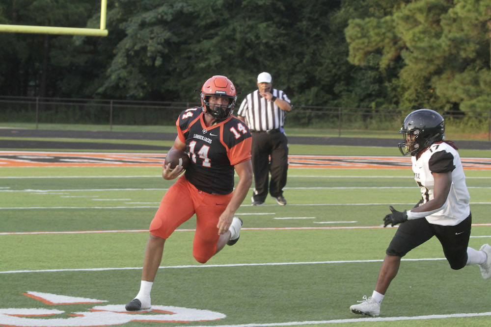 A football player running with the ball in his hand.