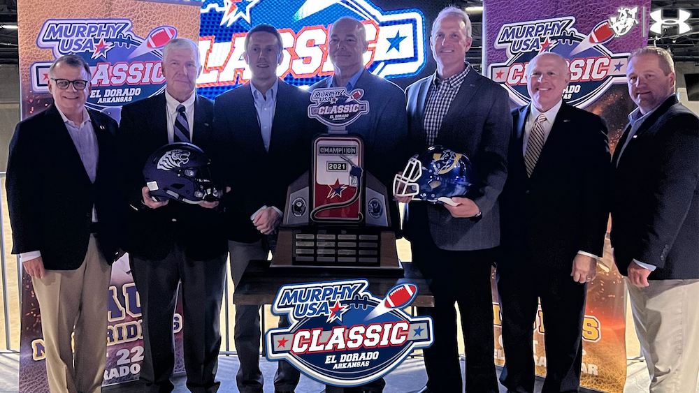 Five men holding helmets and a plaque.