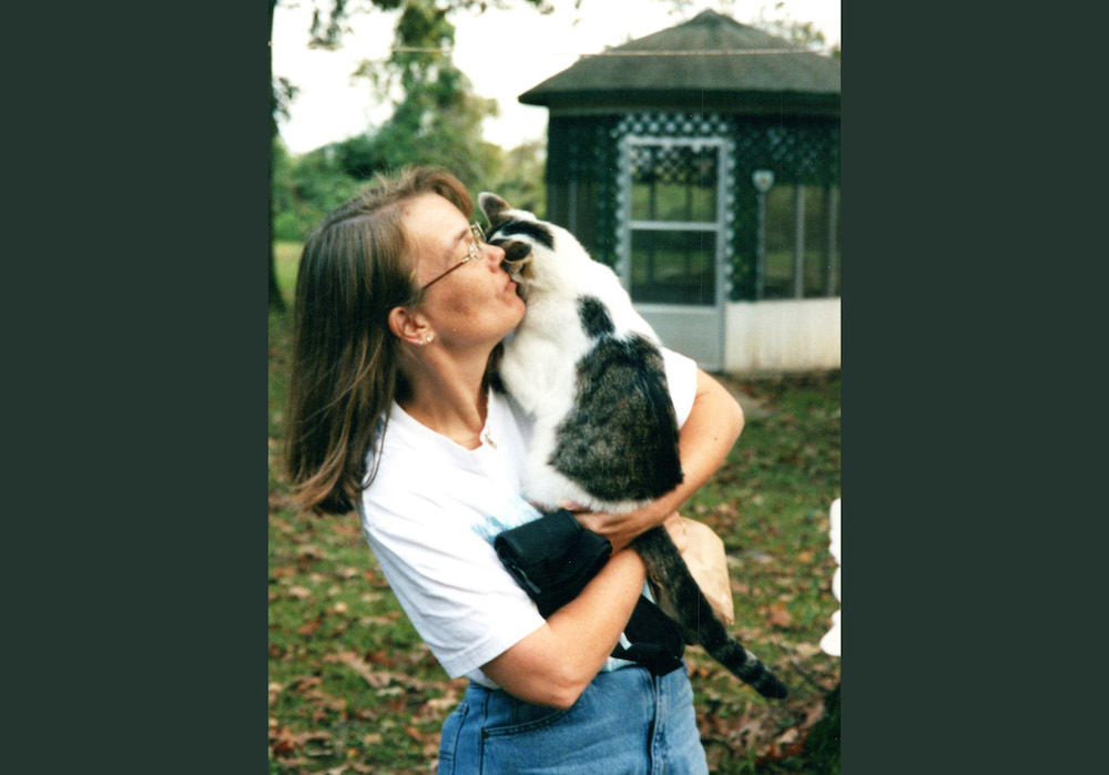 A woman holding a cat in her arms.