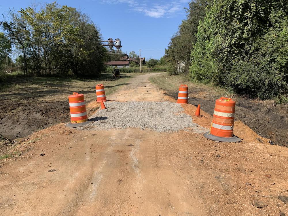 A road with orange cones and gravel on it.