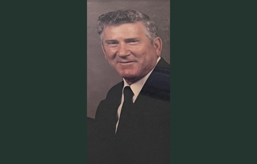A man in a suit and tie smiling for the camera.