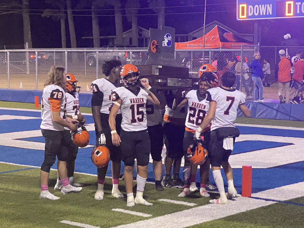 A group of football players standing on top of a field.
