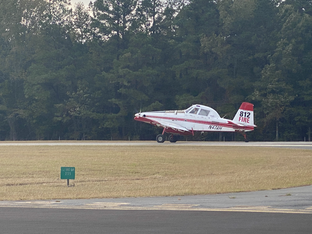A small airplane is on the runway of an airport.