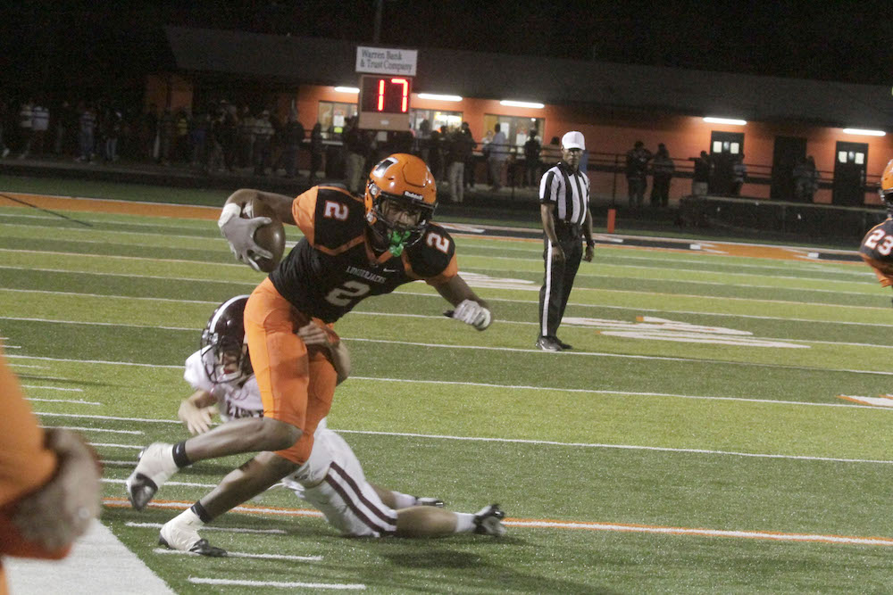 A football player is being tackled by another player.