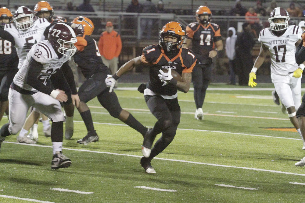 A group of football players running on the field.