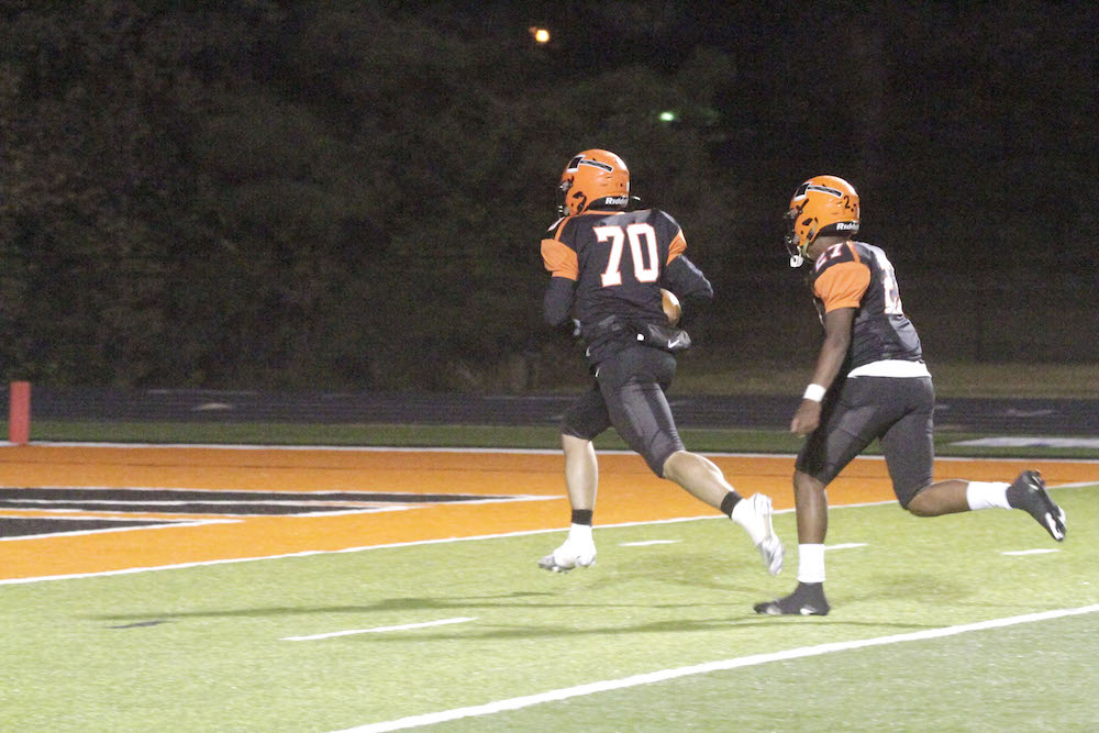 Two football players are playing on a field.