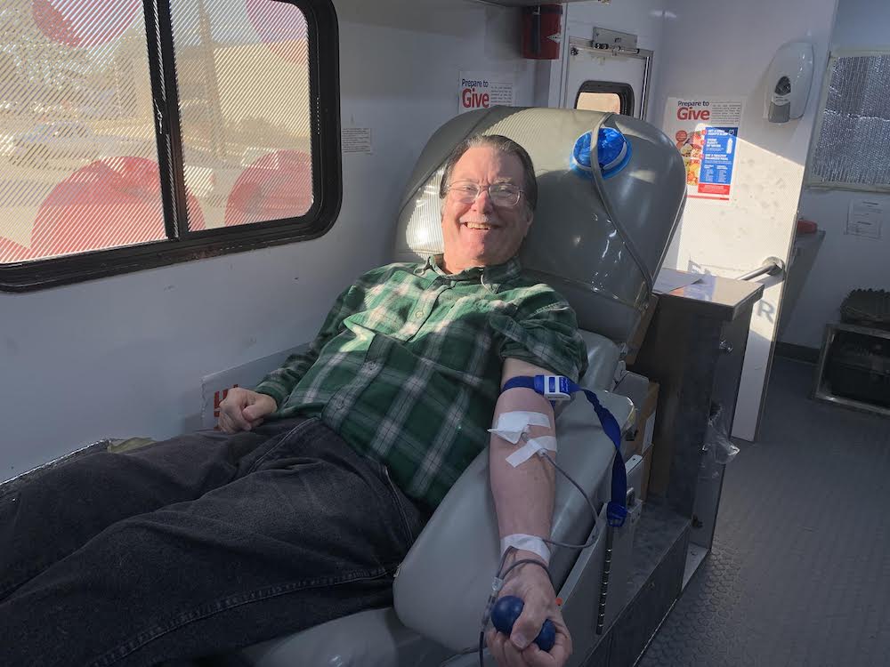 A man sitting in an ambulance with his arm bandaged.