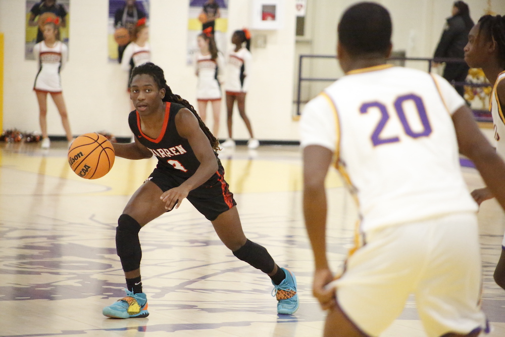 A young person is playing basketball on the court.