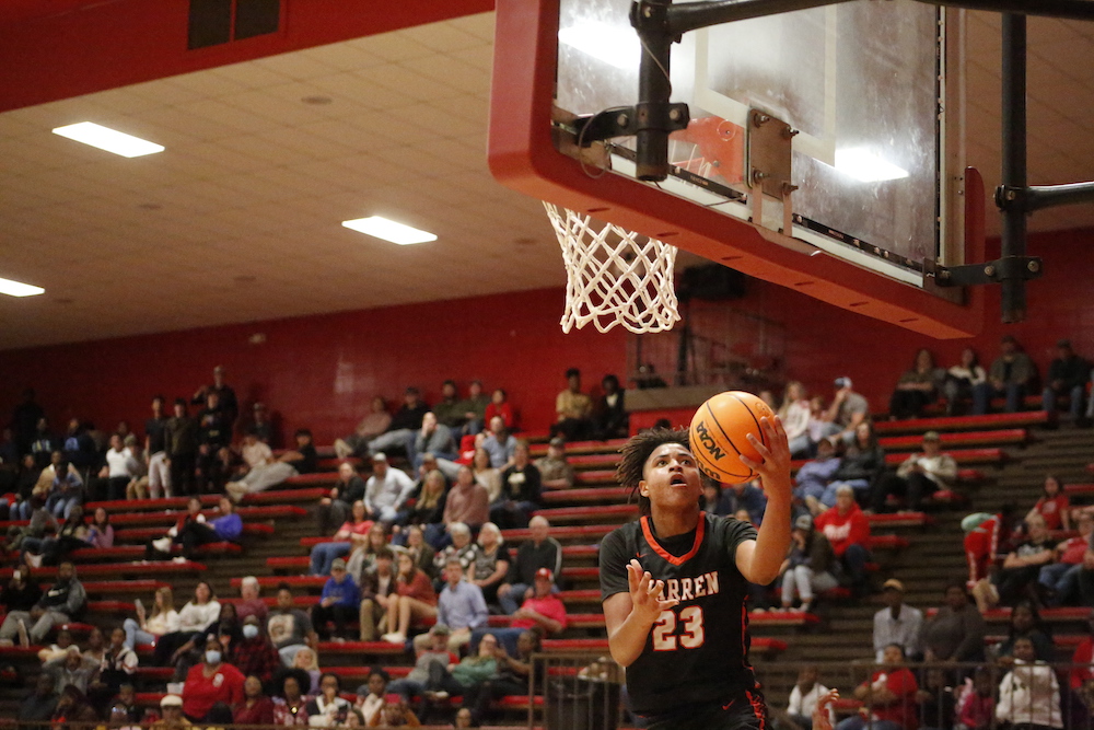 A man in black shirt playing basketball on court.