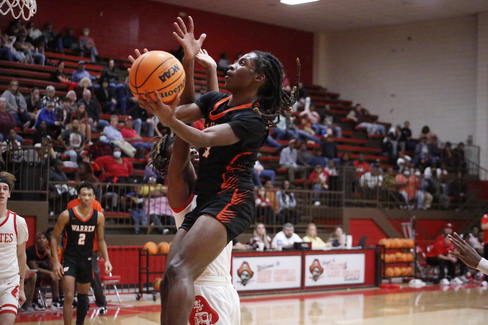 A basketball player is going to the hoop.